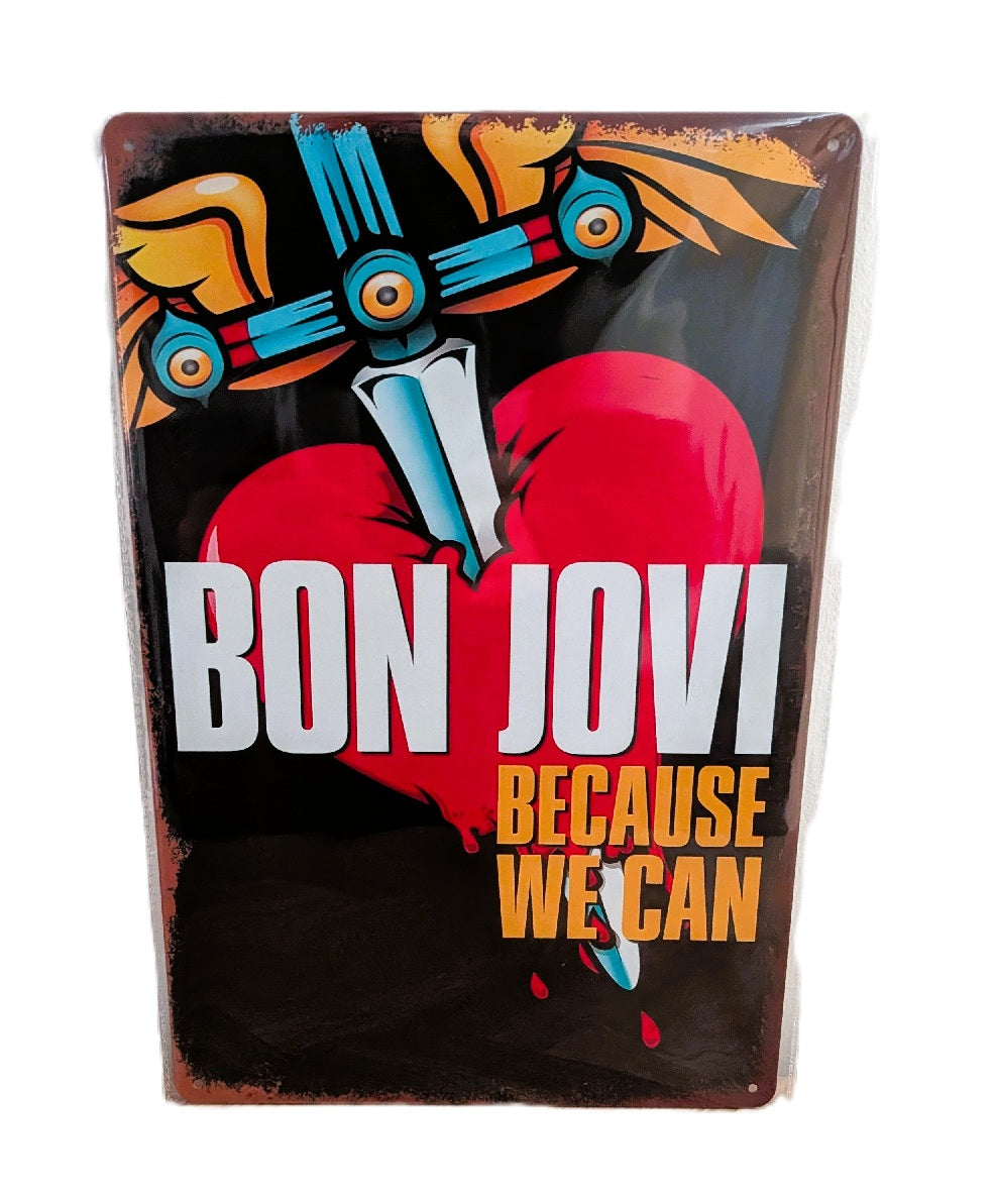 Vertical metal wall sign for Bon Jovi featuring a large red heart pierced by a winged dagger with yellow and blue accents, the band name in bold white text, and 'Because We Can' in orange-yellow typography on a black background.