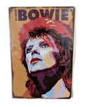Vibrant vertical metal wall sign featuring a faceted pop-art portrait of David Bowie as Ziggy Stardust with fiery orange hair, set against a warm tan background with bold 'DAVID BOWIE' text and distressed edges