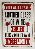 Vintage-style vertical metal wall sign with red and black text that reads 'Being asked if I want another glass of wine is like being asked if I want more money' featuring two wine glass illustrations and distressed edges.