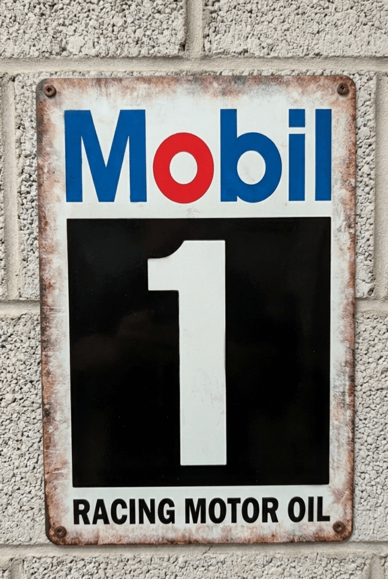 Vintage-style vertical metal wall sign for Mobil 1 Racing Motor Oil featuring the blue and red Mobil logo above a large white number 1 on a black block, with distressed rusted edges