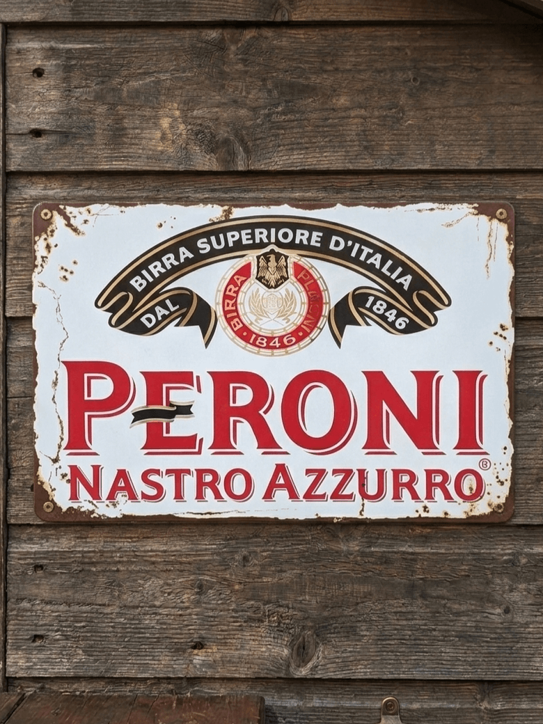 Horizontal vintage-style metal wall sign for Peroni Nastro Azzurro, featuring the red 'PERONI' logo, the Italian crest with 'DAL 1846' ribbons, and 'Birra Superiore D'Italia' text on a distressed white background mounted on a dark wooden wall.