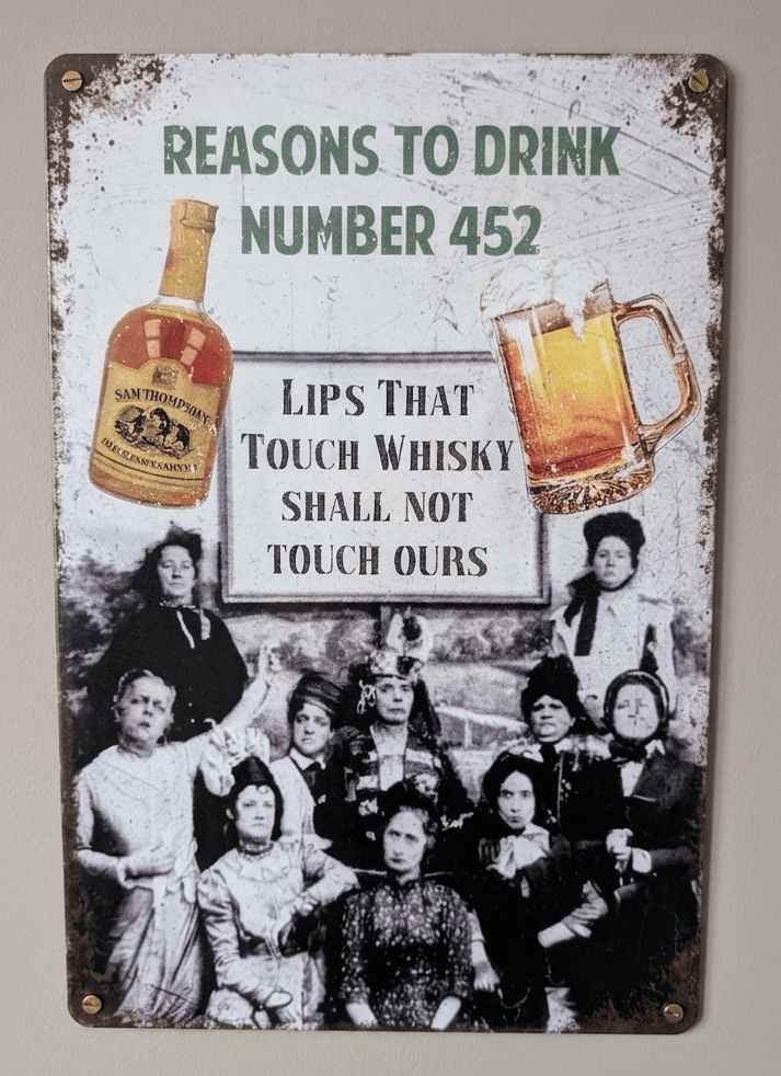 Vertical vintage-style metal wall sign reading 'REASONS TO DRINK NUMBER 452' at the top, featuring a vintage black and white photo of an unamused group of women holding a sign that says 'LIPS THAT TOUCH WHISKY SHALL NOT TOUCH OURS', flanked by color illustrations of a liquor bottle and a frothy beer mug on a distressed white background with heavily rusted borders.