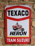 Vertical vintage-style metal wall sign for Texaco Heron Team Suzuki, featuring a racing motorcycle with rider, the Texaco logo, and 'Heron Team Suzuki' text on a distressed white and red background.