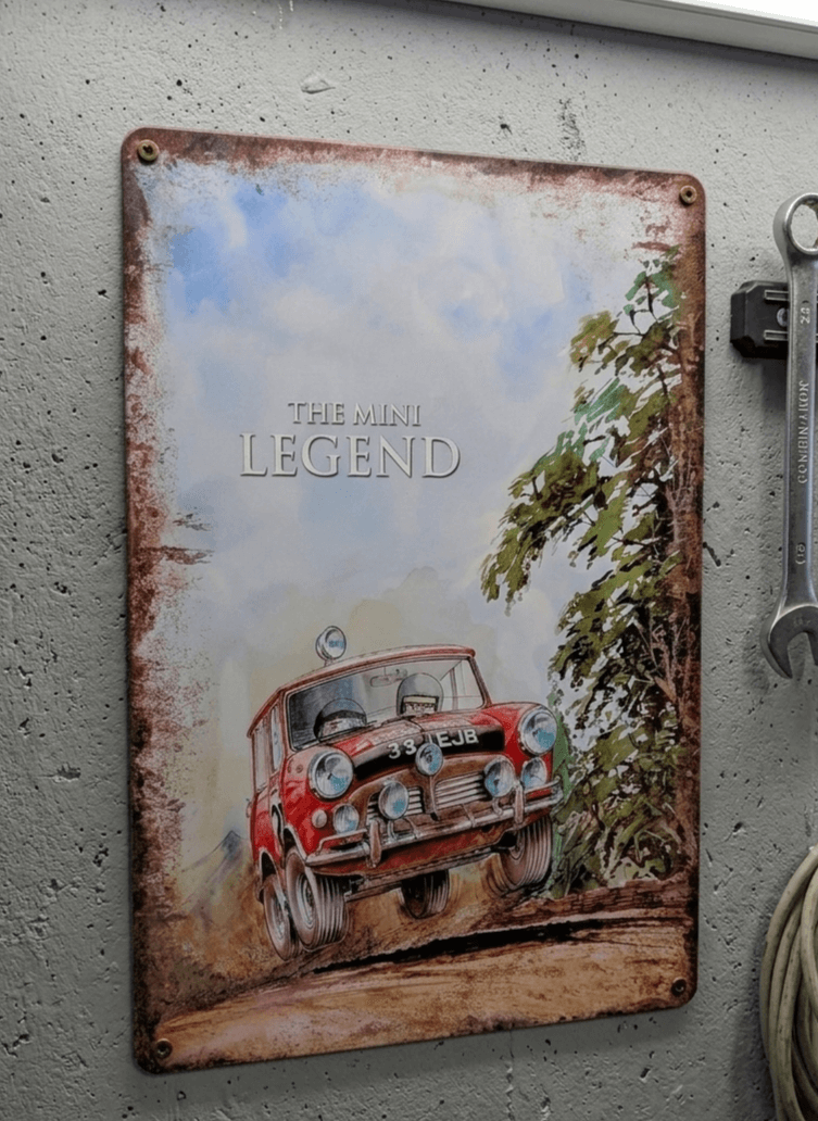 Vintage-style metal wall sign featuring a red classic Mini Cooper rally car with racing number 33 EJB, a heavily rusted border, and the text The Mini Legend