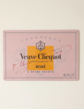 Horizontal pink metal wall sign for Veuve Clicquot Rosé Champagne, featuring the brand's iconic orange-yellow square, anchor logo, and elegant black and red typography on a soft pink background.