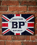 Vintage-style landscape metal wall sign for BP Motor Spirit featuring the Union Jack flag and classic BP shield logo on a distressed white background with rusted edges.