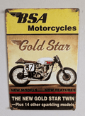 Vertical vintage-style metal wall sign for BSA Motorcycles in protective plastic wrap, featuring a classic silver cafe racer racing bike with the number 37 on a distressed parchment background, topped with a bright yellow header and bold text reading 'THE NEW GOLD STAR TWIN' at the bottom.