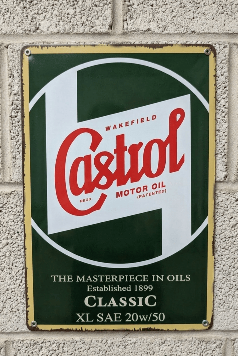 Vintage-style Castrol Motor Oil metal wall sign featuring the classic red script logo on a green and white background with 'The Masterpiece in Oils' slogan and distressed edges