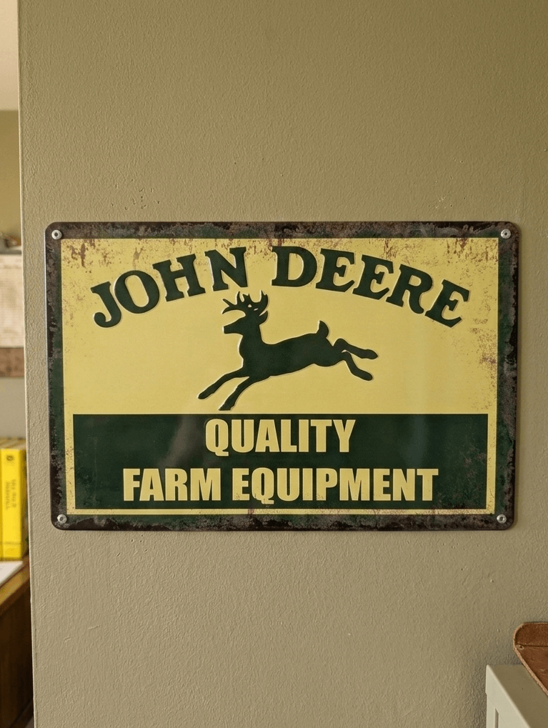 Vintage-style green and yellow metal wall sign featuring the John Deere leaping deer logo and the text Quality Farm Equipment with a heavily rusted and distressed effect
