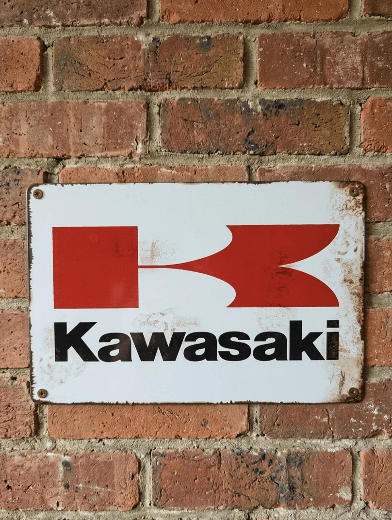 Vintage-style landscape metal wall sign for Kawasaki motorcycles, featuring the classic red 'Flying K' logo and black Kawasaki block lettering on a distressed white background with rusted edges.