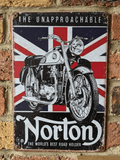 Vertical vintage-style metal wall sign for Norton Motorcycles, featuring a detailed black and white illustration of a classic bike over a distressed Union Jack flag, with 'The Unapproachable' and 'The World's Best Road Holder' text, mounted on a brick wall.