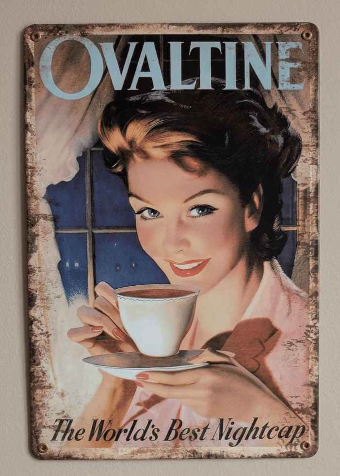 Vertical vintage-style metal wall sign for Ovaltine, featuring a mid-century painted illustration of a smiling woman holding a white teacup and saucer by a window at night, with light blue branding at the top and text reading 'The World's Best Nightcap' against heavily rusted borders.
