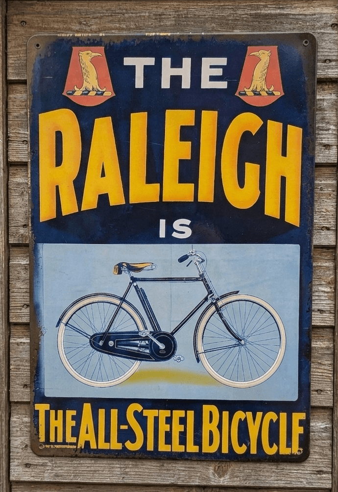Vintage-style navy and yellow metal wall sign for Raleigh Bicycles featuring a classic bicycle illustration and the text The All-Steel Bicycle
