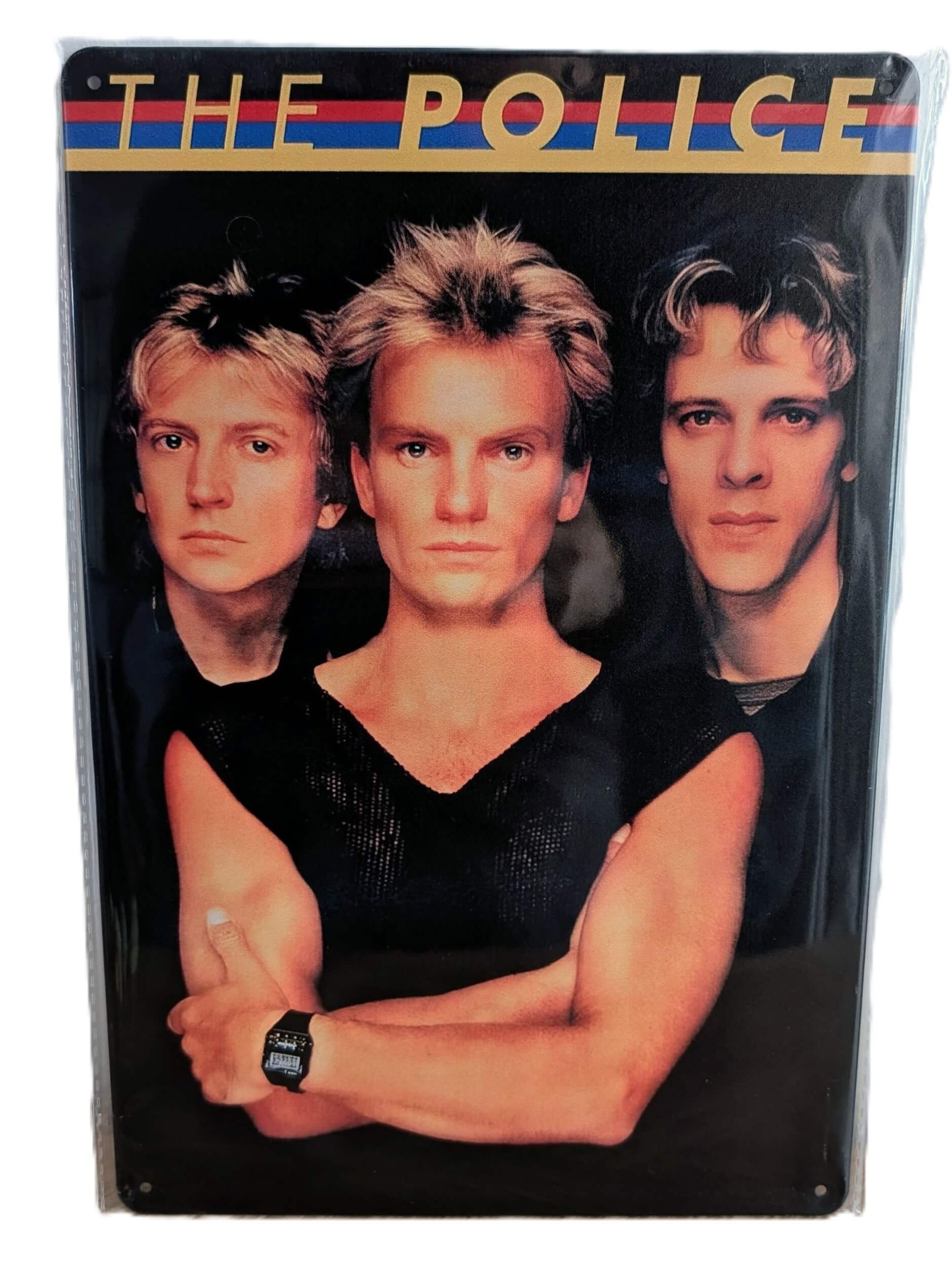 Vertical glossy metal wall sign for The Police in protective plastic wrap, featuring a classic promotional portrait photograph of Andy Summers, Sting, and Stewart Copeland against a black background, topped with a red, blue, and yellow stripe design and bold gold text.