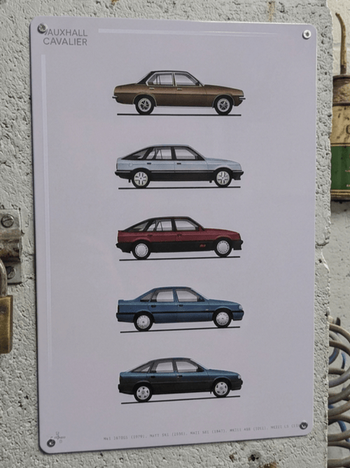 Vertical white metal wall sign mounted on a textured garage wall, showcasing a detailed graphic evolution of five classic Vauxhall Cavalier models from the Mk1 to the Mk3 in profile view, featuring bold 'Vauxhall Cavalier' text in the top left and model specifications printed along the bottom edge.
