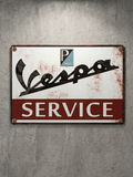 Horizontal vintage-style metal wall sign for Vespa Service, featuring the stylized black Vespa script and Piaggio shield logo on a white top half, with 'SERVICE' in white block text on a red bottom bar, mounted on a concrete wall with rusted edges.