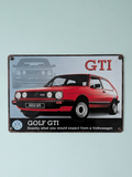 Vintage-style landscape metal wall sign for the Volkswagen Golf GTI, featuring a red Mk2 model in the foreground and a ghosted blue front-view in the background, set against a light blue and black base with weathered edges.